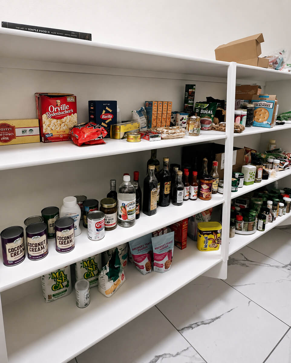 Disorganized pantry with overflowing shelves before professional kitchen organization in Summerlin, Las Vegas — packaged goods hidden behind one another