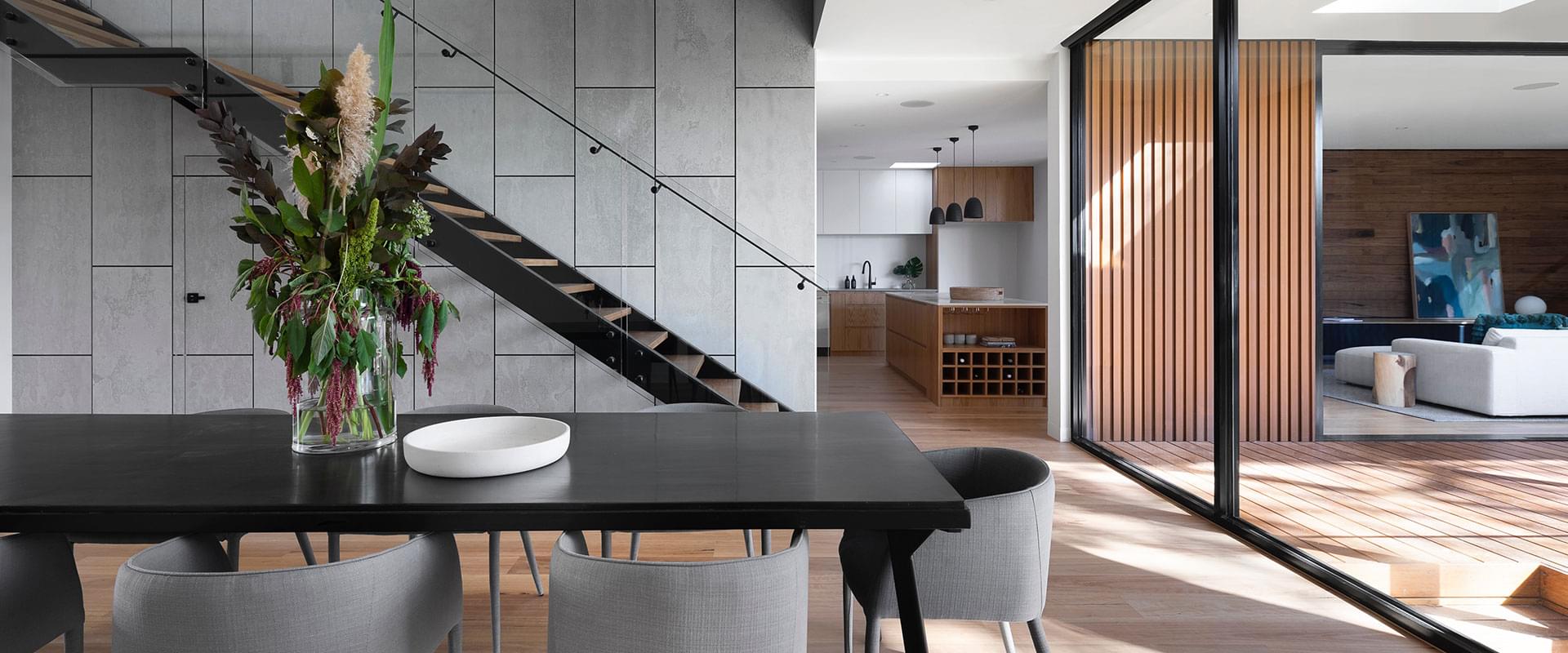 Staged luxury open-plan home interior in Las Vegas — dining room, floating staircase, and designer kitchen styled by Lifelystyle to maximize buyer appeal and listing value for $1M+ properties